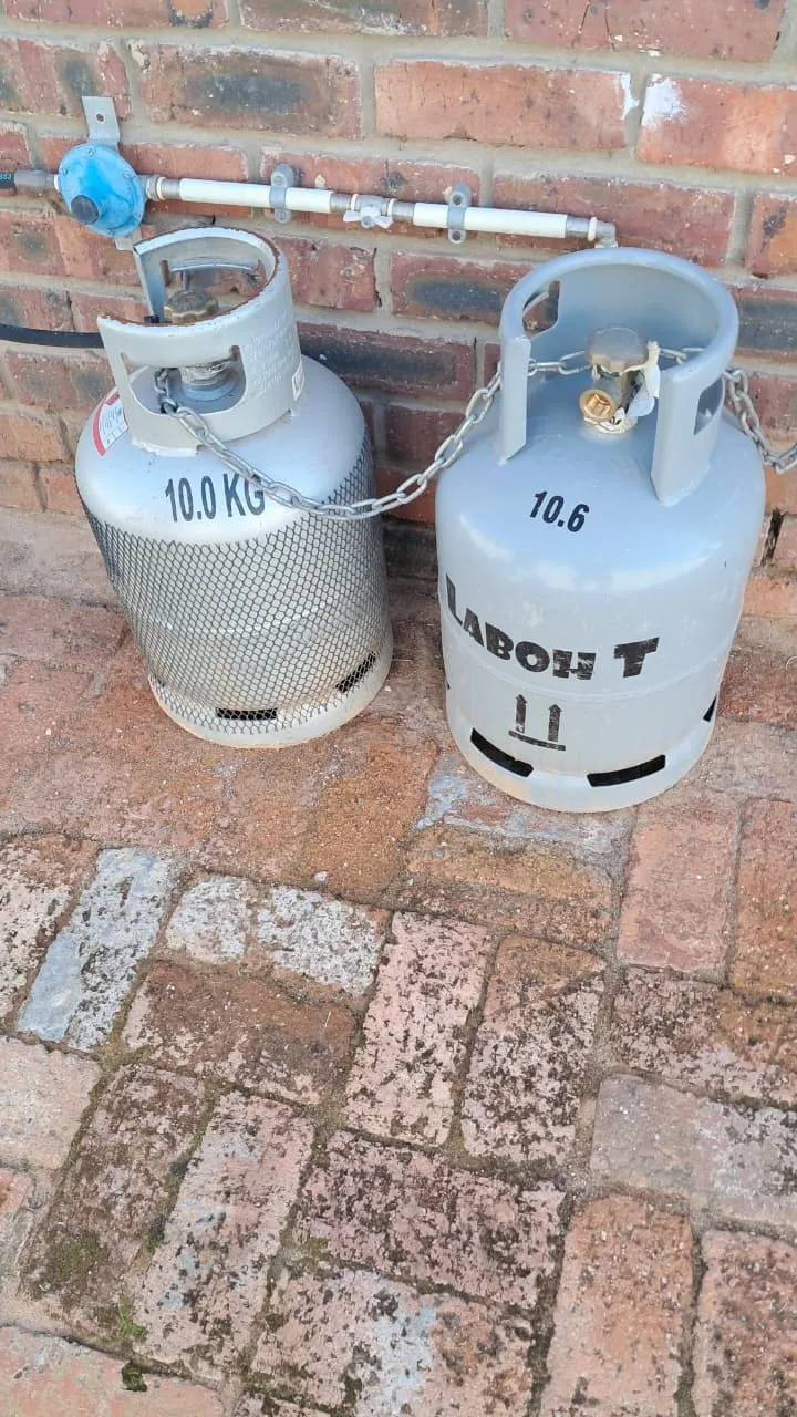 Two 10 kg gas cylinders with change-over regulator, pigtails and safety chain installed for a gas hob in George
