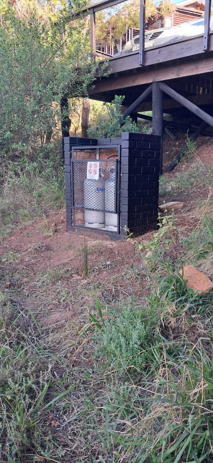Compliant brick gas cylinder cage housing two 19kg bottles at a home in George