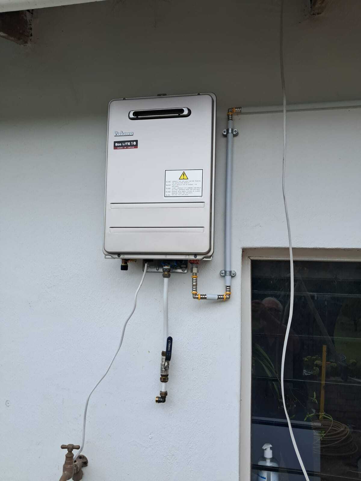 Paloma Eco Lite 16 gas geyser installed on a white wall with neat copper and gas pipework in George